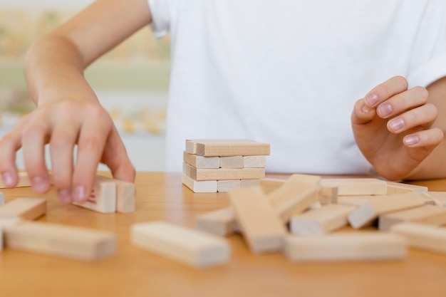 Kind, das eine hölzerne Turmspiel-Nahaufnahme spielt