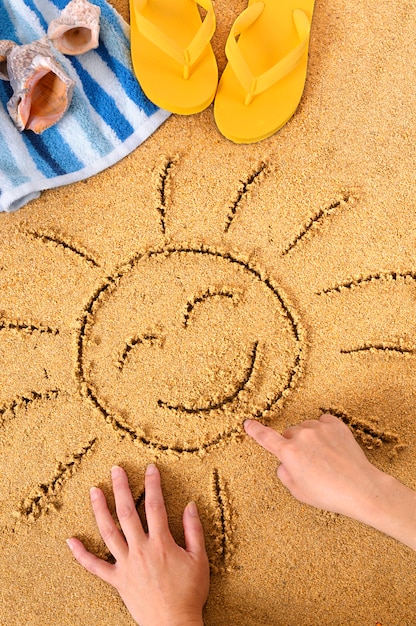 Kind, das eine Sonne Zeichnung im Sand