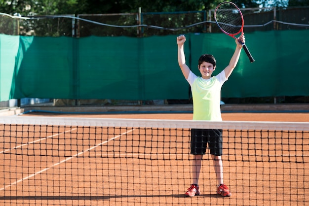 Kind, das Sieg eines Tennisspiels feiert