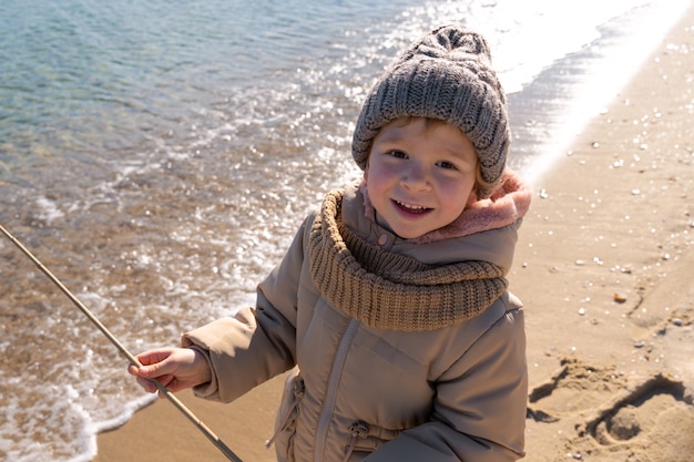 Kostenloses Foto kind, das spaß am hohen winkel des strandes hat