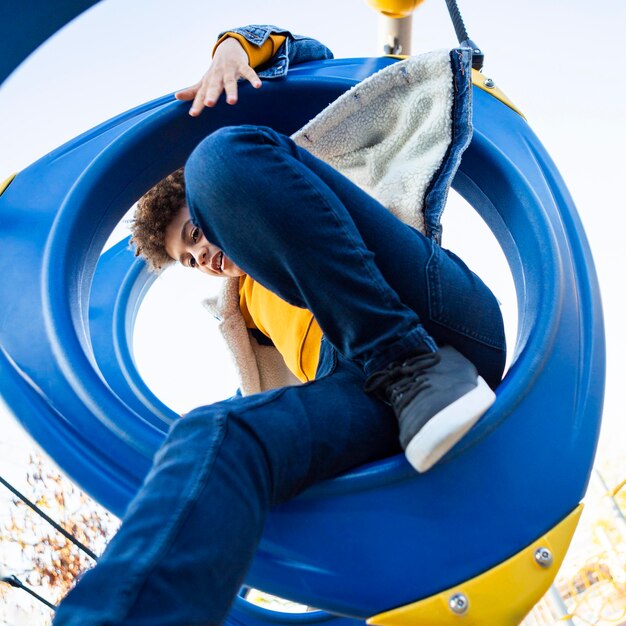 Kind, das Spaß auf dem Spielplatz im Freien hat