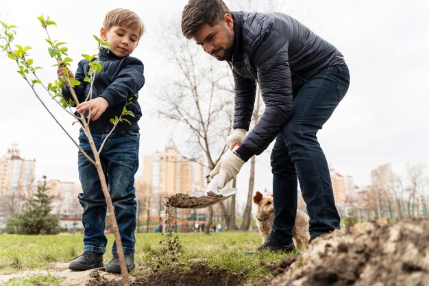 Kind, das versucht, einen Baum im Freien zu pflanzen