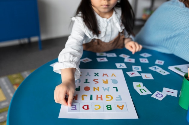 Kostenloses Foto kind des hohen winkels, das mit buchstaben spielt