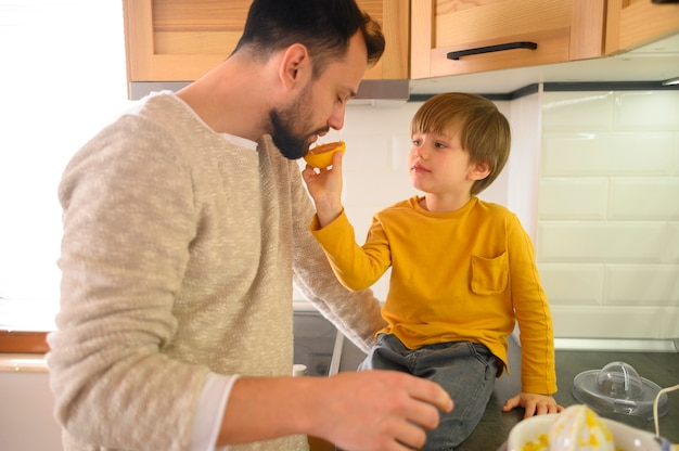 Kind gibt seinem Vater die Hälfte von Orange