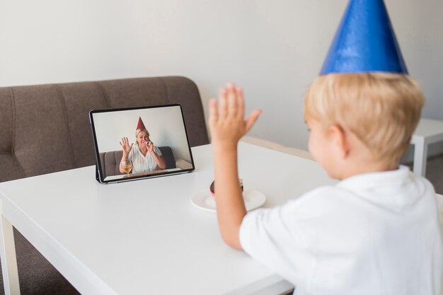 Kind in Quarantäne zu Hause, das Geburtstag über Tablette feiert