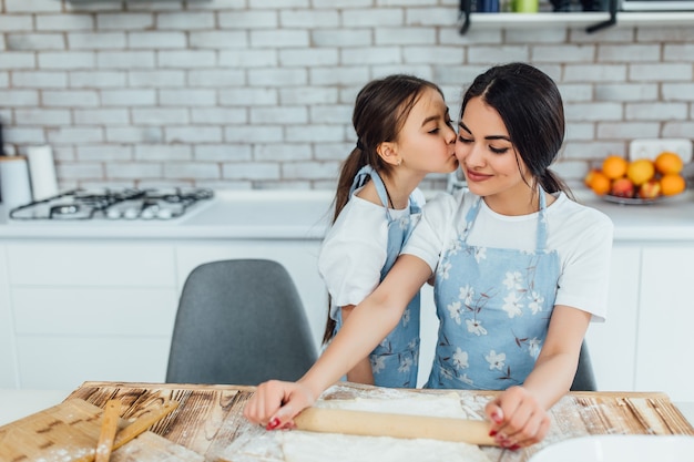 Kind küsst Schwester beim Kochen in der Küche