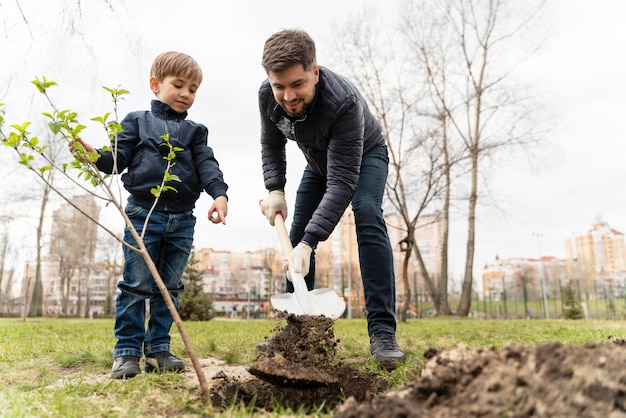 Kind lernt, wie man einen Baum pflanzt