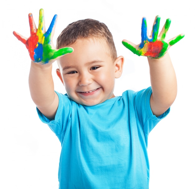 Kind mit den Händen voller Farbe lächelnd