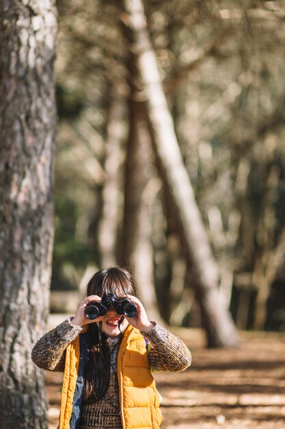 Kind mit Fernglas im Wald