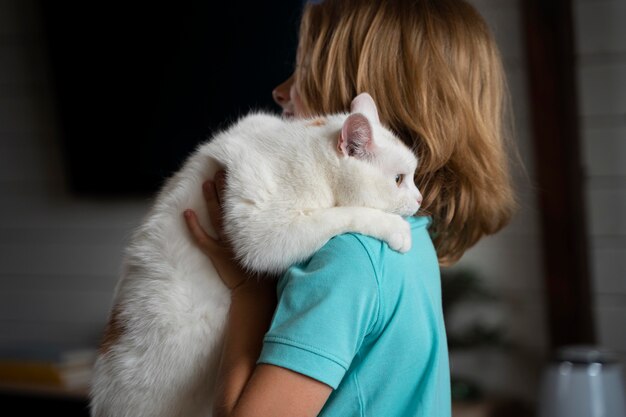 Kind mit mittlerem Schuss, das Katze hält