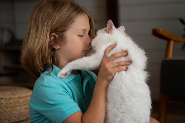 Kind mit mittlerem Schuss, das süße Katze hält