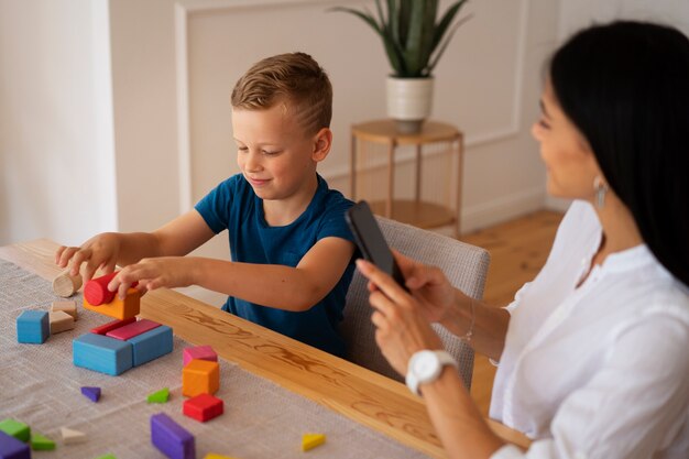 Kind mit seiner Mutter, die eine Denksportaufgabe spielt