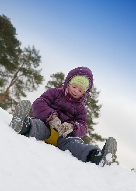 Kind schiebt im Schnee