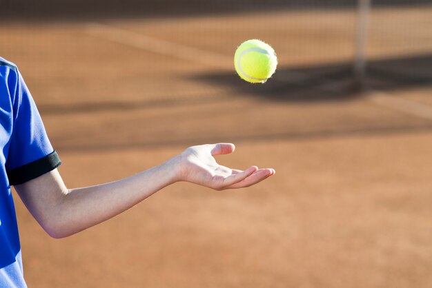 Kind spielt mit dem Tennisball