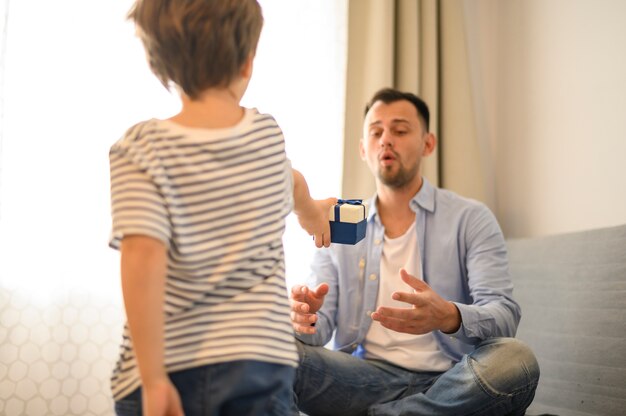 Kind überraschender Vater mit Geschenk