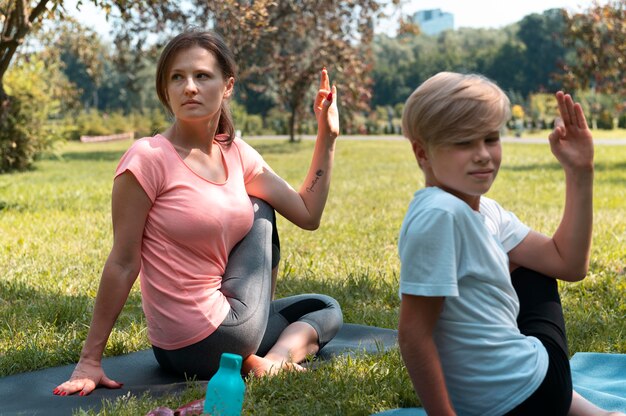 Kind und Frau mit mittlerem Schuss auf Yogamatte