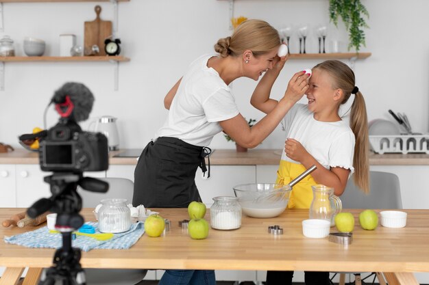 Kind und Frau mit mittlerem Schuss, die Eier halten