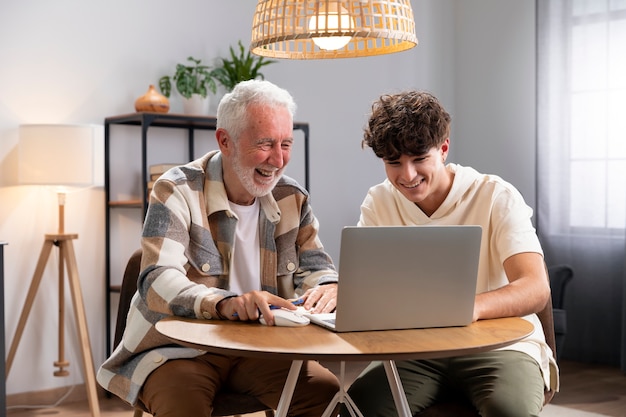 Kind und großvater der mittleren aufnahme mit laptop