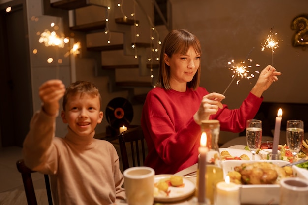 Kostenloses Foto kind und mutter der mittleren aufnahme am tisch