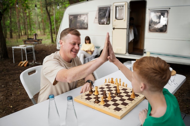 Kind und Vater der Seitenansicht, die Schach spielen