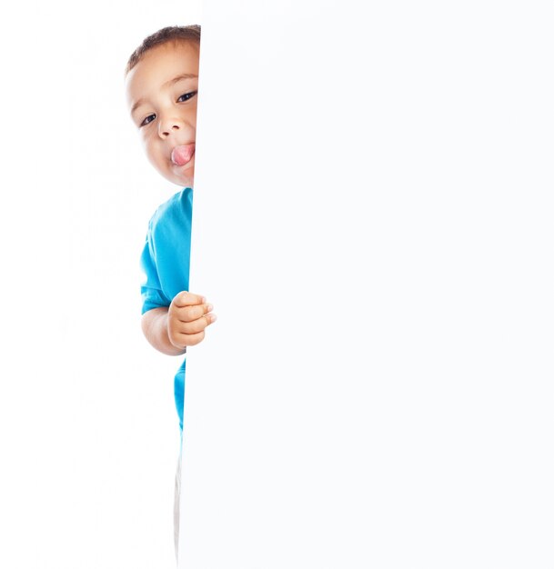 Kind zeigt Zunge und eine leere Plakat