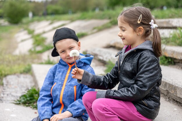 Kinder auf dem Spaziergang kommunizieren und betrachten die Blume