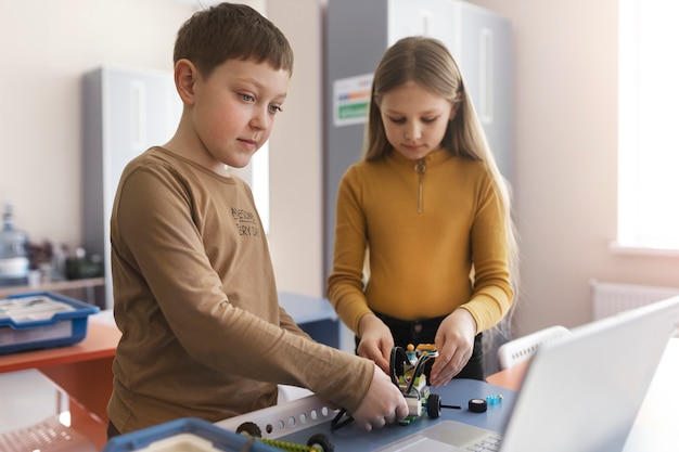 Kinder bauen einen Roboter aus elektronischen Teilen