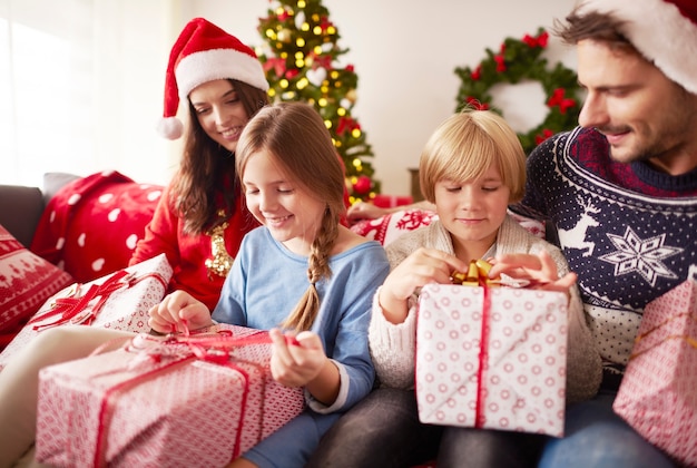 Kinder beginnen Weihnachtsgeschenke zu öffnen