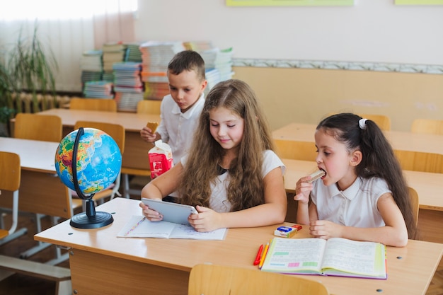 Kinder beobachten Tablet im Klassenzimmer