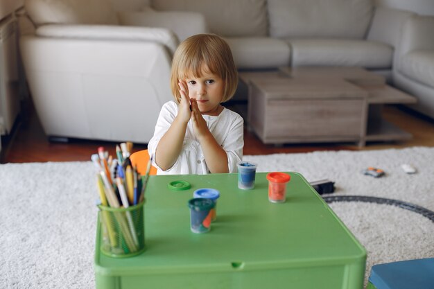 Kinder, die am grünen Tisch und am Zeichnen stationieren