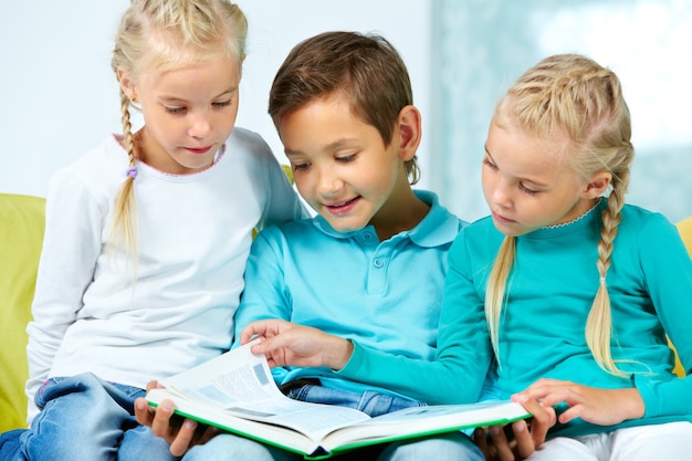 Kostenloses Foto kinder, die auf der couch lesung sitzen