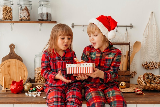 Kinder, die ein Weihnachtsgeschenk zusammenhalten