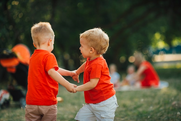 Kinder, die Hände anhalten und draußen spielen