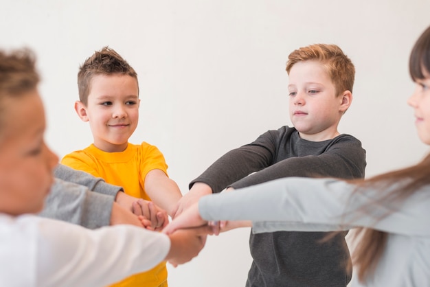 Kinder, die ihre Hände zusammenfügen