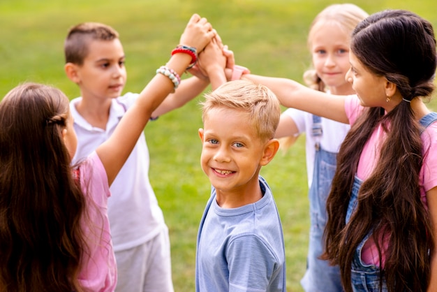 Kinder, die ihre rechten Hände zusammenfügen