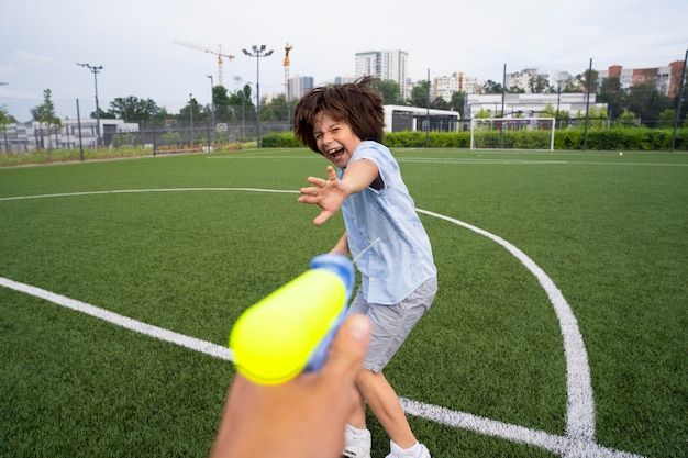 Kinder, die mit Wasserpistole auf dem Feld spielen, hautnah