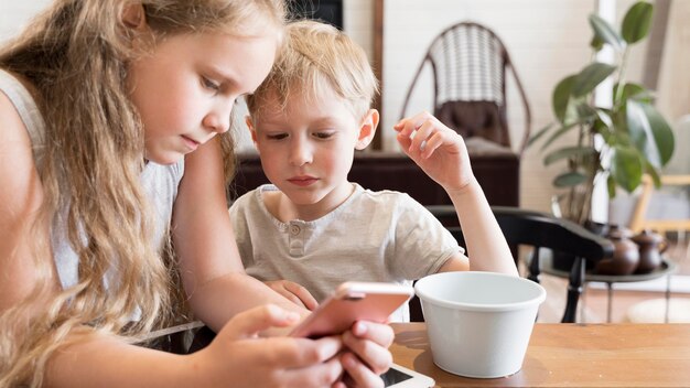 Kinder, die Smartphone betrachten