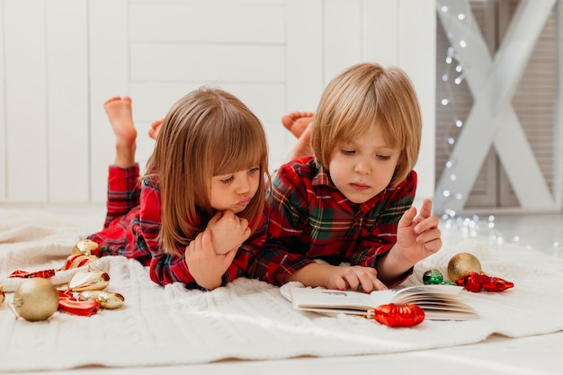 Kinder, die zusammen am Weihnachtstag lesen