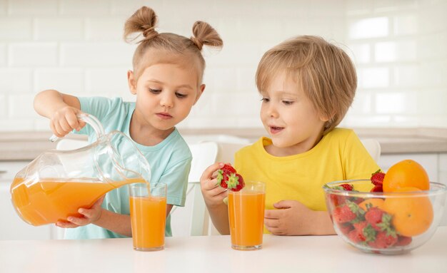 Kinder essen Obst und trinken Saft