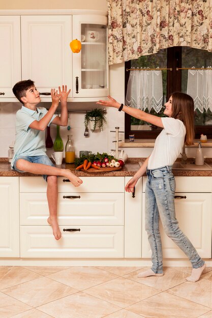 Kinder haben Spaß mit Gemüse in der Küche