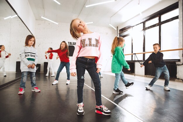 Kinder in der Tanzschule. Ballett-, HipHop-, Street-, Funky- und Modern-Tänzer über Studio-Hintergrund.