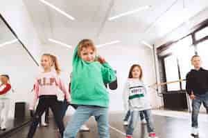 Kostenloses Foto kinder in der tanzschule. ballett-, hiphop-, street-, funky- und modern-tänzer über studio-hintergrund.