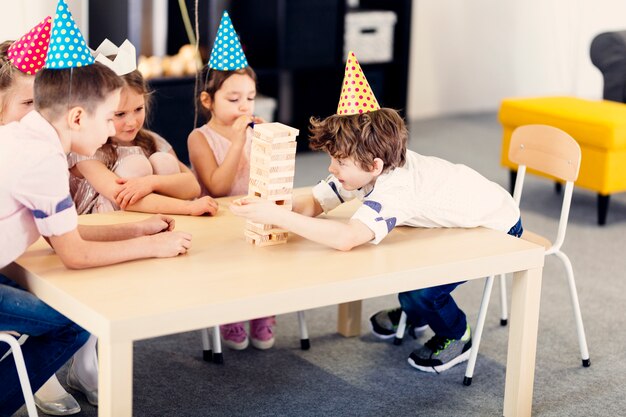 Kinder in farbigen Kappen, die Spiel spielen