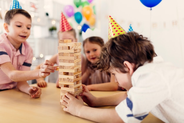 Kinder in farbigen Kappen, die Spiel spielen