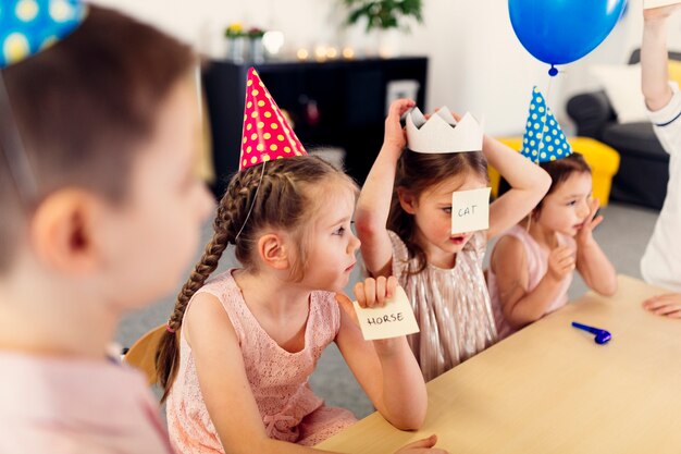 Kinder in farbigen Mützen spielen