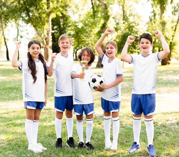 Kinder in Fußballausrüstung sind begeistert von einem neuen Spiel