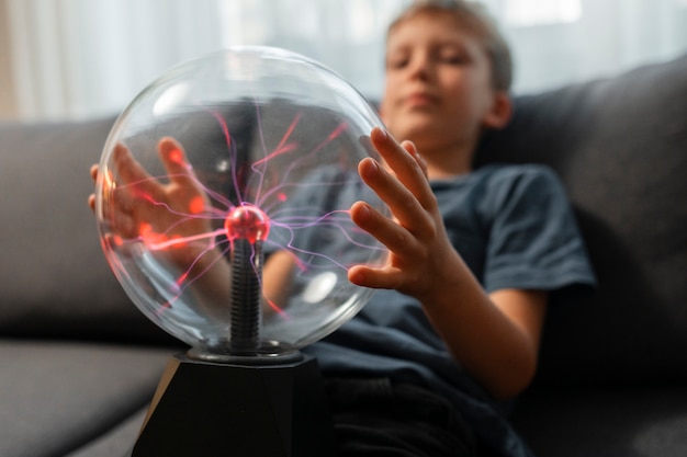Kinder interagieren mit einer Plasmakugel