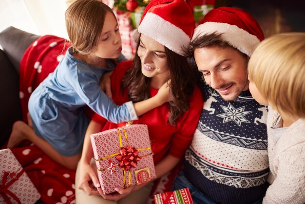 Kinder küssen ihre Eltern zu Weihnachten