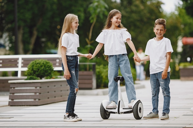 Kinder lernen an einem sonnigen Sommertag in einem Park Hoverboard zu fahren