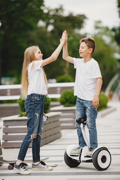 Kinder lernen an einem sonnigen Sommertag in einem Park Hoverboard zu fahren